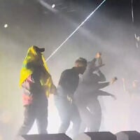 A member of Irish band Kneecap wears a Hezbollah flag at a concert in London on November 21, 2024. (Screen grab/YouTube)