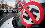 Illustrative: A prohibition sign with a swastika is seen on the bonnet of a car during a demonstration near the fairground in Dresden, Germany on April 10, 2021. (Jens Schlueter/AFP)