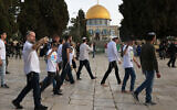 Jewish visitors walk protected by Israeli security forces at the Al-Aqsa mosque compound, also known as the Temple Mount complex to Jews, in Jerusalem on April 9, 2023, during the Muslim holy fasting month of Ramadan, also coinciding with the Jewish Passover holiday. (AHMAD GHARABLI / AFP)