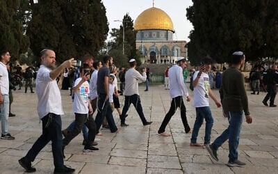 Jewish visitors walk protected by Israeli security forces at the Al-Aqsa mosque compound, also known as the Temple Mount complex to Jews, in Jerusalem on April 9, 2023, during the Muslim holy fasting month of Ramadan, also coinciding with the Jewish Passover holiday. (AHMAD GHARABLI / AFP)