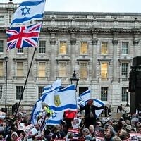 Protesters wave Israeli flags and hold photos of people held hostage by Palestinian terror group Hamas in Gaza, during a demonstration outside Downing Street on November 19, 2023 to protest against antisemitism and to call for the release of the hostages. (JUSTIN TALLIS / AFP)