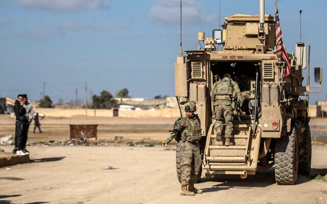US soldiers step into an armored personnel carrier as they patrol an area in the town of Tal Hamis, southeast of the city of Qameshli in Syria's northeastern Hasakeh governorate, on January 24, 2024. (Delil Souleiman/AFP)