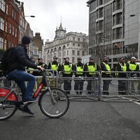 Police officers guard a barrier close to the Israeli embassy, the destination for a National March for Palestine in central London on February 17, 2024. (JUSTIN TALLIS / AFP)