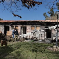 A picture taken on February 14, 2024 in Kibbutz Nirim in southern Israel bordering the Gaza Strip, shows people checking a damaged house following the deadly October 7 attack by Hamas terrorists (Menahem Kahana / AFP)