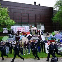 Illustrative: Police forces run past pro-Palestinian, anti-Israel activists at the university campus of the Free University of Berlin, Germany, on May 7, 2024. (Tobias Schwarz/AFP)