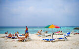 Tourists relax at a beach in Maafushi, an island in Maldives, on October 22, 2024. (Mohamed Afrah / AFP)