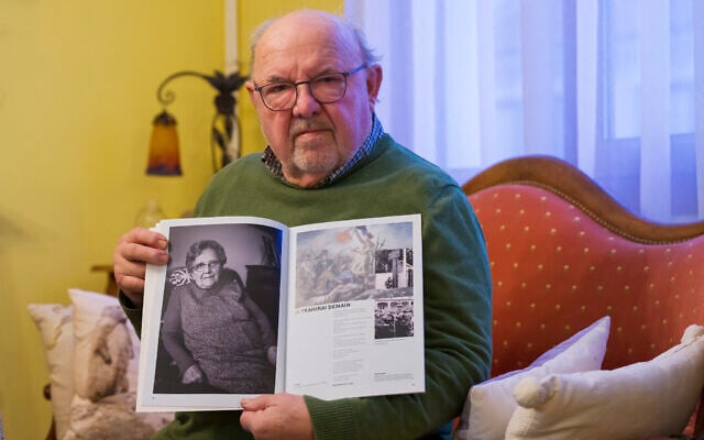 Guy Poirot, born on March 11, 1945 in Ravensbruck concentration camp, poses with a portrait of his mother from the book 'De la resistance' in Nancy, north-eastern France, on December 10, 2024. (Jean-Christophe Verhaegen / AFP)