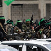 Illustrative: Hamas terrorists carry their guns in Nuseirat in the central Gaza Strip, ahead of the release of Israeli hostages on February 22, 2025. (Bashar Taleb/AFP)