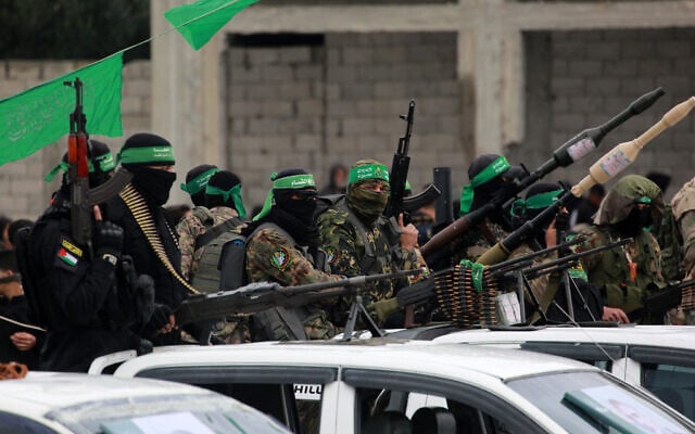 Illustrative: Hamas terrorists carry their guns in Nuseirat in the central Gaza Strip, ahead of the release of Israeli hostages on February 22, 2025. (Bashar Taleb/AFP)