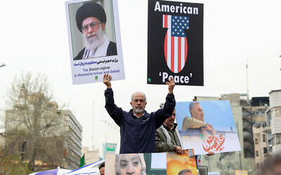 A man holds a portrait of the Iranian Supreme Leader and an anti-US sign as Iranians attend a rally marking Al-Quds Day (Jerusalem), a commemorative day held annually on the last Friday of the Muslim fasting month of Ramadan, in Tehran, on March 28, 2025. (AFP)