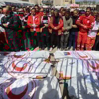 Members of the Palestinian Red Crescent and other emergency services pray by the bodies of fellow rescuers killed a week earlier by Israeli forces, during a funeral procession at Nasser hospital in Khan Younis in the southern Gaza Strip on March 31, 2025. Israel has said at least six were Hamas operatives. (Eyad Baba/AFP)