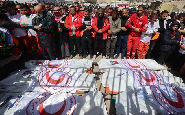 Members of the Palestinian Red Crescent and other emergency services pray by the bodies of fellow rescuers killed a week earlier by Israeli forces, during a funeral procession at Nasser hospital in Khan Younis in the southern Gaza Strip on March 31, 2025. Israel has said at least six were Hamas operatives. (Eyad Baba/AFP) Members of the Palestinian Red Crescent and other emergency services pray by the bodies of fellow rescuers killed a week earlier by Israeli forces, during a funeral procession at Nasser hospital in Khan Younis in the southern Gaza Strip on March 31, 2025. Israel has said at least six were Hamas operatives. (Eyad Baba/AFP)
