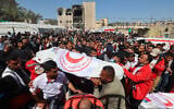 Members of the Palestine Red Crescent and other emergency services carry bodies of fellow rescuers killed a week earlier by Israeli forces, during a funeral procession at the Nasser Medical Complex in the southern Gaza Strip's Khan Younis, March 31, 2025. (Eyad Baba / AFP)