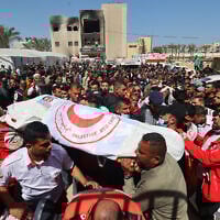 Members of the Palestine Red Crescent and other emergency services carry bodies of fellow rescuers killed a week earlier by Israeli forces, during a funeral procession at the Nasser Medical Complex in the southern Gaza Strip's Khan Younis, March 31, 2025. (Eyad Baba / AFP)