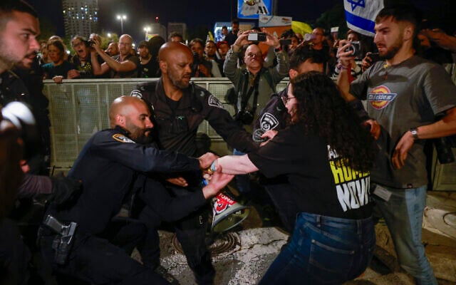 MK Naama Lazimi is pulled by police officers during a protest  outside the Knesset in Jerusalem, on March 31, 2025. (Photo by Menahem Kahana / AFP)
