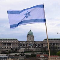 Illustrative; An Israeli flag is raised on the Széchenyi Chain Bridge, with the Buda Castle in Budapest in the background on April 2, 2025, as preparations are under way for the visit of Israel's Prime Minister Benjamin Netanyahu. (Attila KISBENEDEK / AFP)