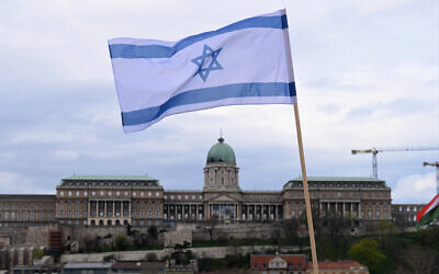 An Israeli flag is raised on the Széchenyi Chain Bridge, with the Buda Castle in Budapest in the background on April 2, 2025, as preparations are under way for the visit of Israel's Prime Minister Benjamin Netanyahu. (Attila KISBENEDEK / AFP)