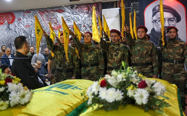 Men dressed in military fatigues stand next to the coffins of Hezbollah official Hassan Bdeir (R) and his son Ali (L) who were killed in an Israeli strike that targeted their apartment the previous day, ahead of their funeral procession in Beirut's southern suburbs on April 2, 2025. (ANWAR AMRO / AFP) Men dressed in military fatigues stand next to the coffins of Hezbollah official Hassan Bdeir (R) and his son Ali (L) who were killed in an Israeli strike that targeted their apartment the previous day, ahead of their funeral procession in Beirut's southern suburbs on April 2, 2025. (ANWAR AMRO / AFP)