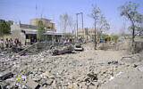 People assess the damage following reported overnight strikes that Huthi rebels said hit the Water Management building in Mansouriya in Yemen's Hodeida governorate, on April 2, 2025. (AFP)