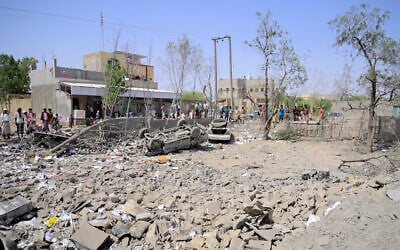 People assess the damage following reported overnight strikes that Huthi rebels said hit the Water Management building in Mansouriya in Yemen's Hodeida governorate, on April 2, 2025. (AFP)