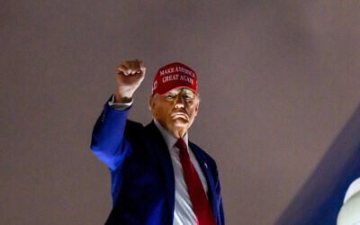US President Donald Trump pumps his fist as he boards Air Force One before departing Miami International Airport, in Miami, Florida on April 3, 2025. Trump is travelling to his Mar-a-Lago Resort. (Mandel NGAN / AFP)