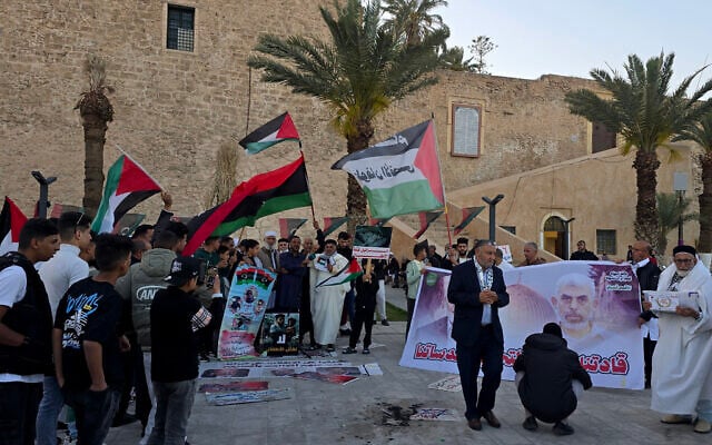 Libyans wave flags and hold a banners with portraits of Hamas's slain leaders Yahya Sinwar and Ismail Haniyeh (not seen) during a demonstration in solidarity with Gaza at Martyrs Square in the capital Tripoli on April 4, 2025. (Mahmud Turkia / AFP)