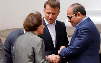 Egypt's President Abdel Fattah al-Sisi (R) and French President Emmanuel Macron (C) shake hands upon arrival at Arish International Airport near Egypt's northeastern city of Arish in the north of the Sinai peninsula, about 55 kilometers west of the border with the Gaza Strip, on April 8, 2025. (Ludovic Marin/Pool/AFP)