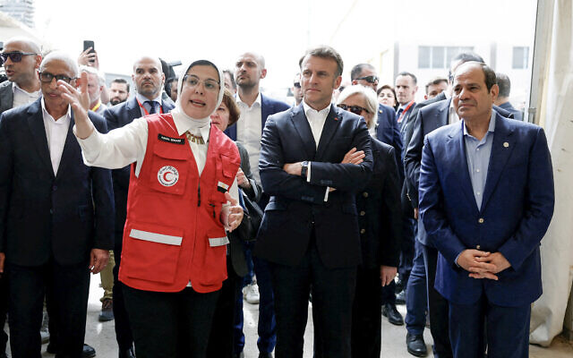 French President Emmanuel Macron (CR), Egyptian President Abdel Fattah al-Sissi (R) and France's Minister for Europe and Foreign Affairs Jean-Noel Barrot (CL) listen to Dr Amal Emam, CEO of the Egyptian Red Crescent (2nd L), as they visit Egyptian Red Crescent warehouses storing aid for Gaza, in the Egyptian border town of El-Arish, Egypt, on April 8, 2025. (Photo by Benoit Tessier / POOL / AFP)