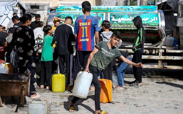 Displaced Palestinians line up to fill their containers with water at the Bureij refugee camp in the central Gaza Strip on April 10, 2025. (Eyad BABA / AFP) Displaced Palestinians line up to fill their containers with water at the Bureij refugee camp in the central Gaza Strip on April 10, 2025. (Eyad BABA / AFP)