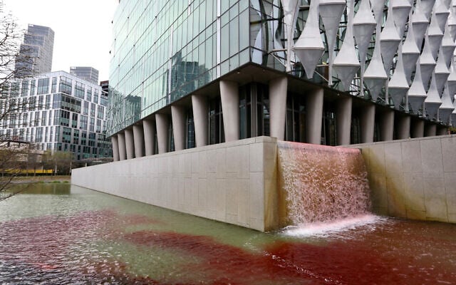 A handout picture released by environmental action group Greenpeace UK on April 10, 2025, shows blood-red dye in the US Embassy pond in London in a protest over arms sales to Israel. (Greenpeace United Kingdom / AFP)