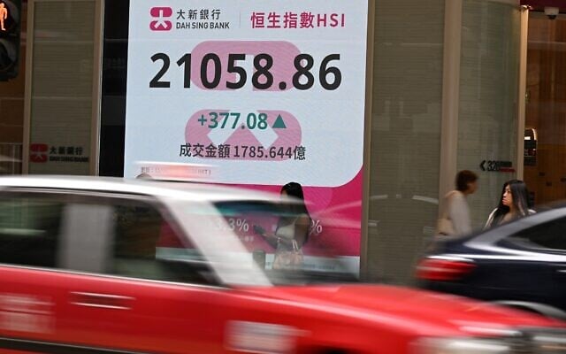 Vehicles pass in front of an electronic sign board showing the Hang Seng Index in Hong Kong on April 11, 2025. (PETER PARKS / AFP) Vehicles pass in front of an electronic sign board showing the Hang Seng Index in Hong Kong on April 11, 2025. (PETER PARKS / AFP)