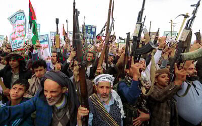 Demonstrators shout slogans and raise their assault rifles during a rally in solidarity with Palestinians in the Gaza Strip and in condemnation of US strikes, outside Sanaa's Saleh Grand Mosque in Yemen's Houthi-controlled capital on April 11, 2025. (Mohammed HUWAIS / AFP)