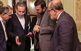 This handout picture provided by Khabar Online on April 12, 2025, shows Iran's Foreign Minister Abbas Araghchi (2nd-L) speaking with members of the Iranian delegation after a meeting in Muscat during nuclear talks with the US. (KhabarOnline / AFP)