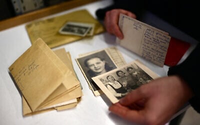 An employee shows photos, former belongings of victims and survivors of Nazi regime, in a storage house at the Arolsen Archives in Bad Arolsen, Germany on March 6, 2025. (Ina Fassbender/AFP)