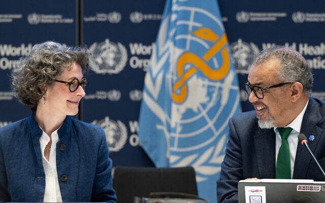 A handout photograph taken and released by the World Health Organisation (WHO) on April 16, 2025 shows Co-chair of the negotiations and French ambassador for Global Health Anne-Claire Amprou (L) and WHO Director-General Tedros Adhanom Ghebreyesus after a consensus on the Pandemic Agreement at the WHO headquarters. (Christopher BLACK / World Health Organization / AFP)