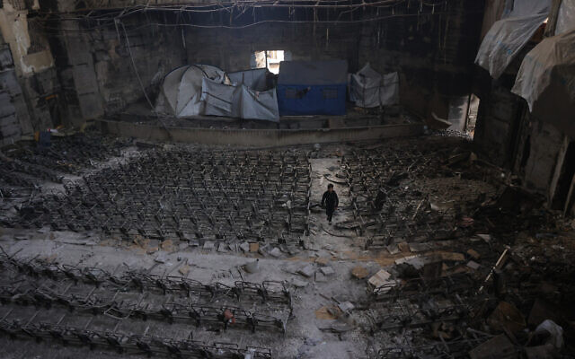 A boy inspects the auditorium in the heavily damaged Islamic University campus where Palestinian families took refuge, in Gaza City on April 16, 2025. (Photo by BASHAR TALEB / AFP)