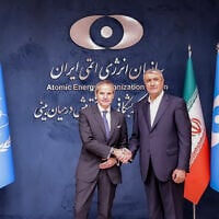 This handout picture made available by the Iranian Atomic Organization (AEOI) office shows the Director-General of the International Atomic Energy Agency (IAEA) Rafael Grossi (L) being received by the head of the AEOI Mohammad Eslami (R) in Tehran on April 17, 2025. (Atomic Energy Organization of Iran / AFP)