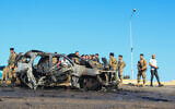 Lebanese soldiers inspect the site near a burnt-out vehicle hit by an Israeli drone strike in Ghazieh, near Sidon, on April 18, 2025. (Mahmoud ZAYYAT / AFP)