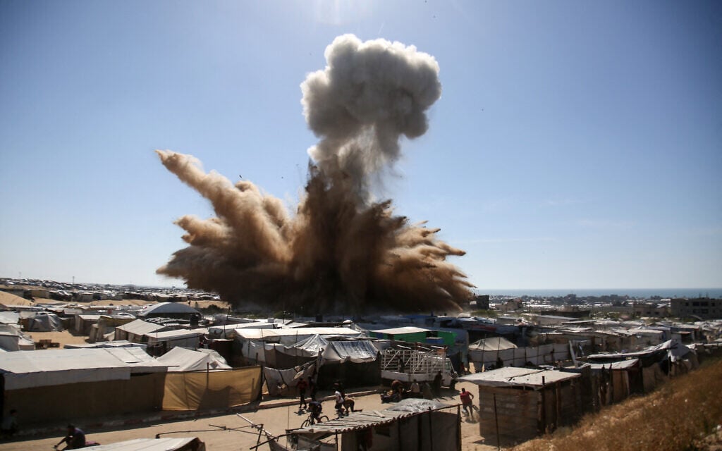 People run for cover as a plume of smoke rises above tents at a camp for displaced Palestinians in northern Khan Younis in the southern Gaza Strip, during an Israeli strike on April 19, 2025. (AFP)