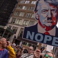 A person shouts next to an image of US President Donald Trump as Nazi dictator Adolf Hitler, as people take part in a protest organized to 'Protect Migrants, Protect the Planet' on April 19, 2025 in New York City. (Adam Gray/Getty Images/AFP)