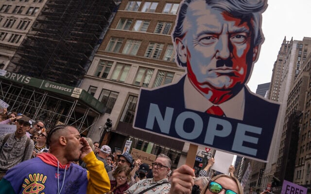 A person shouts next to an image of US President Donald Trump as Nazi dictator Adolf Hitler, as people take part in a protest organized to 'Protect Migrants, Protect the Planet' on April 19, 2025 in New York City. (Adam Gray/Getty Images/AFP)