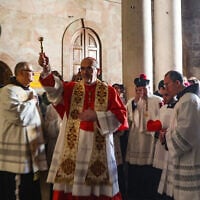 Latin Patriarch of Jerusalem Pierbattista Pizzaballa (C) sprinkles holy water during the Easter mass at the Holy Sepulchre Church in Jerusalem's Old City on April 20, 2025. (GIL COHEN-MAGEN / AFP)
