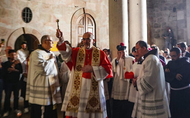 Latin Patriarch of Jerusalem Pierbattista Pizzaballa (C) sprinkles holy water during the Easter mass at the Holy Sepulchre Church in Jerusalem's Old City on April 20, 2025. (GIL COHEN-MAGEN / AFP)