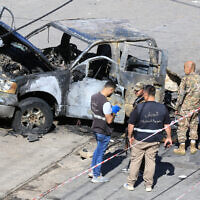 Lebanese army soldiers inspect a burnt-out vehicle in Braiqaa in south Lebanon's Nabatiyeh district, April 20, 2025. (Mahmoud ZAYYAT / AFP)