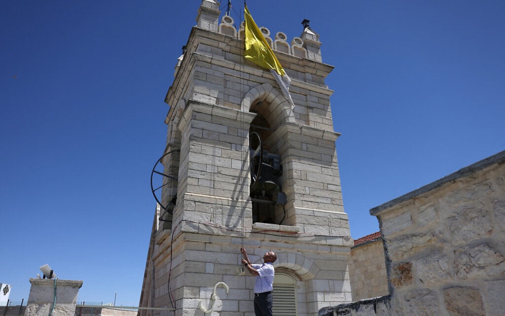 A man lowers the Vatican flag in the Old City of Jerusalem on April 21, 2025 after the death of Pope Francis. (Photo by AHMAD GHARABLI / AFP)