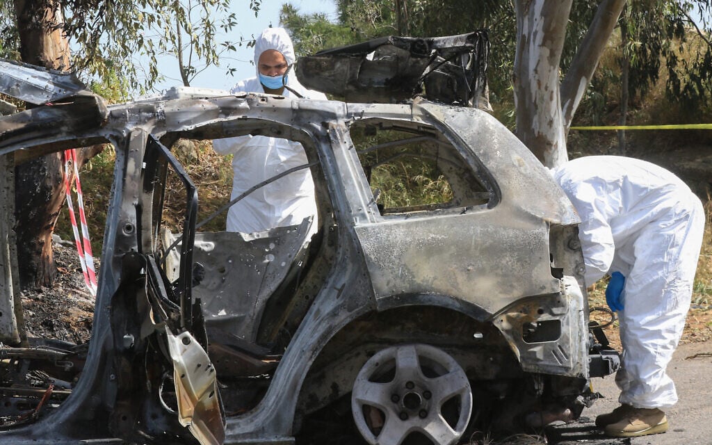 Members of the Lebanese army forensic team inspect a destroyed car after it was targeted by an Israeli airstrike near the coastal town of Damour, about 20 kilometers south of Beirut, on April 22, 2025. (Mahmoud Zayyat/AFP)
