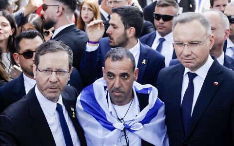 President Isaac Herzog (L) poses with fomer hostage Eli Sharabi (C), and Poland's President Andrzej Duda (R) in front of the 'Arbeit macht frei' (Work will set you free) gate at the Auschwitz Birkenau concentration camp in Oswiecim, Poland, on April 24, 2025, prior to the March of the Living (Wojtek Radwanski/AFP)