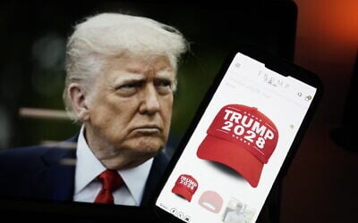This photo illustration, taken on April 24, 2025, in Washington, DC, shows an image of US President Donald Trump alongside a smartphone displaying a red 'Trump 2028' cap on the Trump Store website (Oliver Contreras / AFP)