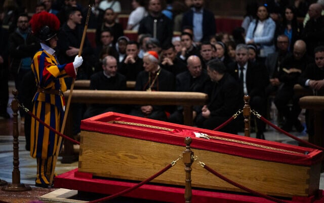 A Swiss guard stands next to the coffin of late Pope Francis as he lies in state at the St Peter's Basilica in the Vatican, a day prior to the Pope's funeral, on April 25, 2025 (MARCO BERTORELLO / AFP)