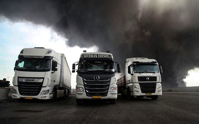 Black smoke rises behind abandoned trucks following an explosion at the Shahid Rajaee port dock southwest of Bandar Abbas in the Iranian province of Hormozgan on April 26, 2025. (MOHAMMAD RASOLE  MORADI / IRNA / AFP)